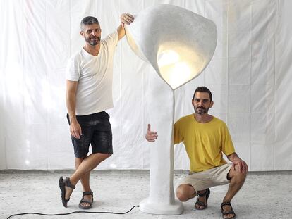 Los diseñadores junto a una de sus esculturas lumínicas.