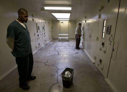 El trabajador preso James Tate, izquierda, mientras el guardia Matt Matteson habla con un interno a través de la puerta de la celda de aislamiento en la cárcel del condado de Dane en Madison. 






