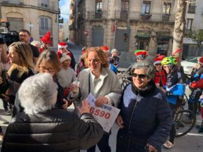 Silvia y Pepa, de frente, agraciadas con un décimo de la lotería de Navidad, con Mercedes Guerrero, de espaldas, otra de las afortunadas por el lotero de Alcoi.