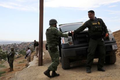 Un miembro de la Guardia Nacional de México da la mano a un oficial de Aduanas y Protección Fronteriza de los Estados Unidos mientras patrullan la cerca entre México y EE UU desde Tijuana (México).