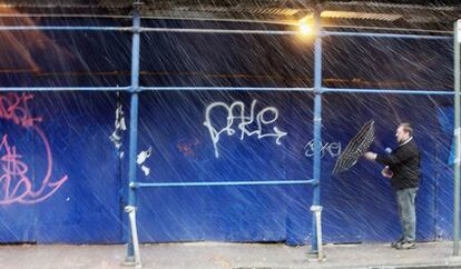 El viento ha conseguido invertir el paraguas que sostiene este hombre en Nueva York.