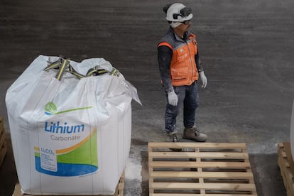 Un trabajador revisa bolsas con polvo de carbonato de litio, adecuado para baterías.