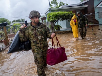 Members of the Puerto Rico National Guard rescue a woman stranded in her house in the aftermath of Hurricane Fiona in Salinas, Puerto Rico September 19, 2022.  REUTERS/Ricardo Arduengo