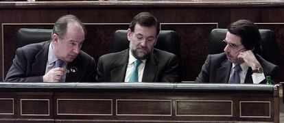 El presidente del Gobierno, José María Aznar (d), el vicepresidente primero, Mariano Rajoy y Rodrigo Rato durante el Pleno del Congreso en el que se debatió el apoyo del Gobierno a una posible guerra con Irak.