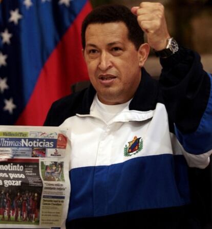 El presidente venezolano saluda puño en alto con un periódico venezolano en la mano