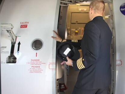 Un piloto de Iberia accede a la cabina de su avión.