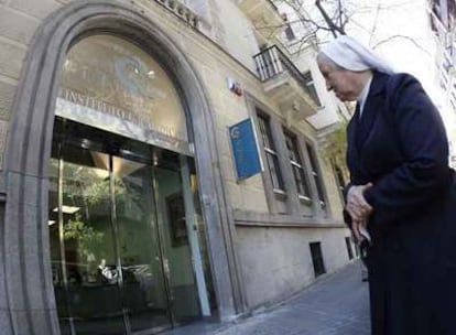 Una religiosa observa la entrada de la clínica de interrupciones de embarazo cuya actividad ha suspendido el Gobierno regional.