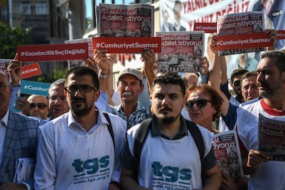 Compa&ntilde;eros de los periodistas detenidos y manifestantes sostienen copias del diario &#039;Cumhuriyet&#039; el inicio del juicio contra 19 de sus empleados y directivos este lunes en Estambul.