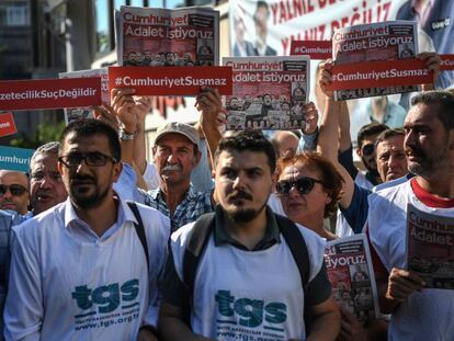 Compa&ntilde;eros de los periodistas detenidos y manifestantes sostienen copias del diario &#039;Cumhuriyet&#039; el inicio del juicio contra 19 de sus empleados y directivos este lunes en Estambul.