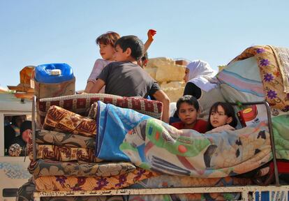 Niños refugiados sirios en la parte de atrás de un vehículo preaprados para cruzar la frontera de vuelta a Siria desde Arsal (Líbano), en julio de 2018.