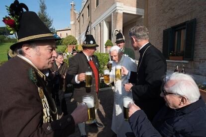 El papa emérito Benedicto XVI brinda con cerveza para celebrar su 86 cumpleaños en compañía de su hermano Georg Ratzinger, a la derecha, monseñor Georg Gaenswein, en su residencia de Castel Gandolfo.