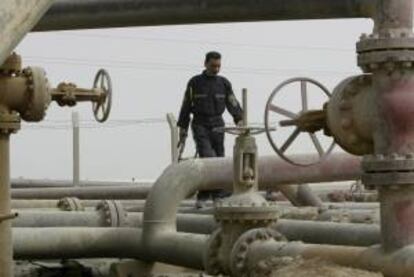 Un vigilante de seguridad camina entre varias tuberías de una refinería cerca de la ciudad porteña de Umm Quasar en Basora, al sur de Irak. EFE/Archivo