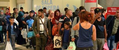 Refugiados hacen cola para comprar un billete para el norte Europa en la estaci&oacute;n de autobuses de M&eacute;ndez &Aacute;lvaro en Madrid.