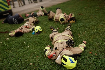 Los bomberos se toman un descanso después de que un incendio forestal quemara áreas en Santa Juana, cerca de Concepción (Chile). Los cientos de bomberos desplegados en el terreno, unos 3.300 brigadistas de la Corporación Chilena de la Madera (Corma), están trabajando para controlar los focos de fuego.