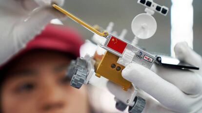 Un trabajador inspecciona un modelo miniatura del vehículo lunar para la sonda china Chang'e 4, en una fábrica en Dongguan, China. 