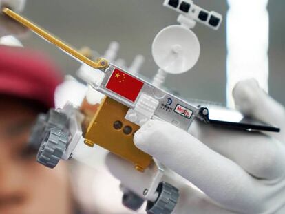 Un trabajador inspecciona un modelo miniatura del vehículo lunar para la sonda china Chang'e 4, en una fábrica en Dongguan, China. 