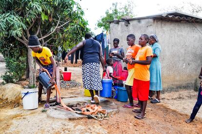 Vecinos de un barrio de Harare hacen cola para recoger agua. 