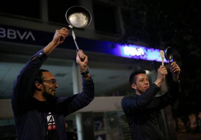 Manifestantes participan golpean cacerolas como gesto de protesta en Bogotá.