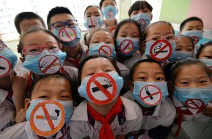 Un grupo de niños llevan máscaras con signos de no fumar para apoyar el día mundial sin tabaco en una escuela primaria de Handan, provincia de Hebei del norte de China. 