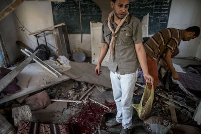 Vários palestinos observam o que restou de uma sala de aula na escola de Yabalia depois do ataque com vários projéteis, em 30 de julho de 2014.