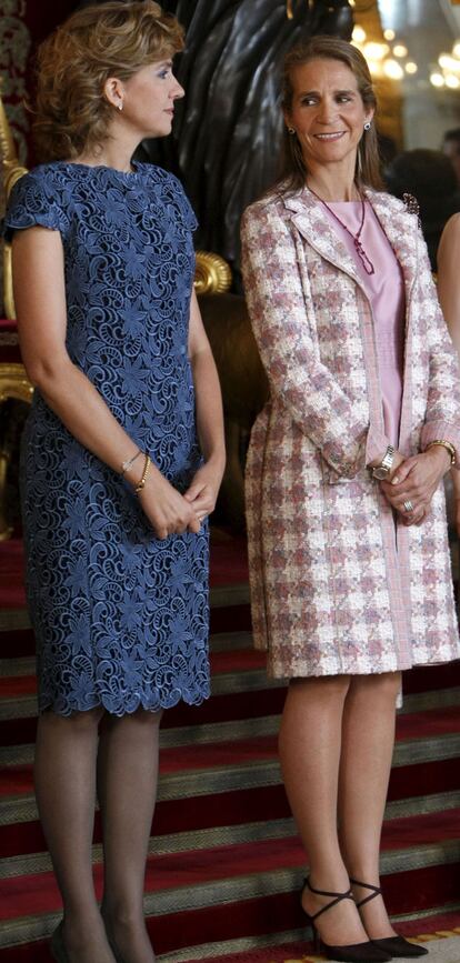 Las infantas Elena y Cristina sacaron de su armario dos vestidos que conjuntaron con abrigos de entretiempo. La infanta Cristina en tonos azules y la infanta Elena en rosa. Ellas fueron fieles al protocolo