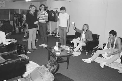Parte del grupo Queen (Roger Taylor -con un vaso- Freddie Mercury - a la derecha- y Brian May -su melena a la izquierda-) en un concierto en Nishinomiya, Japón, en 1982. De pie, a la izquierda de la imagen (con un jersey oscuro y un vaso en la mano), Paul Prenter, mirando a Mercury.