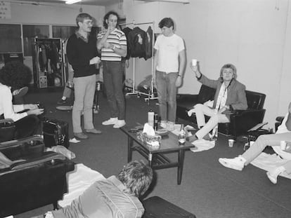 Parte del grupo Queen (Roger Taylor -con un vaso- Freddie Mercury - a la derecha- y Brian May -su melena a la izquierda-) en un concierto en Nishinomiya, Japón, en 1982. De pie, a la izquierda de la imagen (con un jersey oscuro y un vaso en la mano), Paul Prenter, mirando a Mercury.