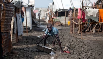 Un niño sostiene un barreño en una de las calles embarradas del campo de desplazados de Malakal, Sudán del Sur.