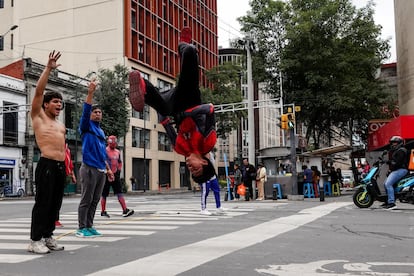 Un grupo de jóvenes realizan acrobacias en un cruce de calles de Ciudad de México, en junio de 2024.
