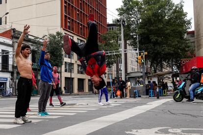 Un grupo de jóvenes realizan acrobacias en un cruce de calles de Ciudad de México, en junio de 2024.