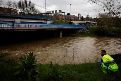 Un trabajador municipal vigila la crecida del río Manzanares en Madrid, este viernes.