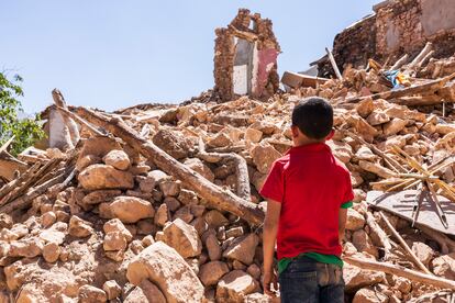 En la imagen, I., de 10 años,  huérfano de padre, observa las ruinas donde ha muerto su madre y su hermana en el terremoto.