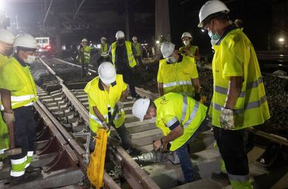 Varios operarios trabajan en las obras que Adif está ejecutando en las vías de la estación de Barcelona-Sants.