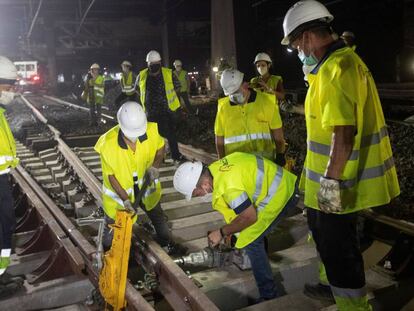 Varios operarios trabajan en las obras que Adif está ejecutando en las vías de la estación de Barcelona-Sants.