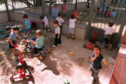 Niños jugando con triciclos en el patio de las guardería Bambi, en Barcelona.