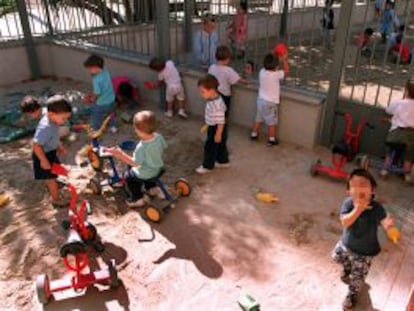 Niños jugando con triciclos en el patio de las guardería Bambi, en Barcelona.