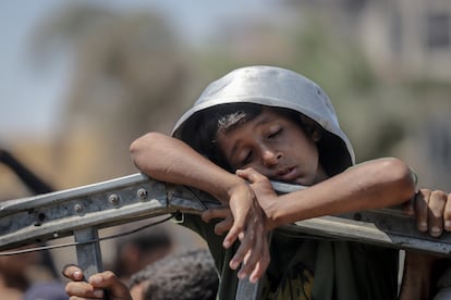 Un niño se protege del sol con el recipiente vacío mientras espera el reparto de comida en la ciudad de Gaza el pasado viernes 25 de julio.