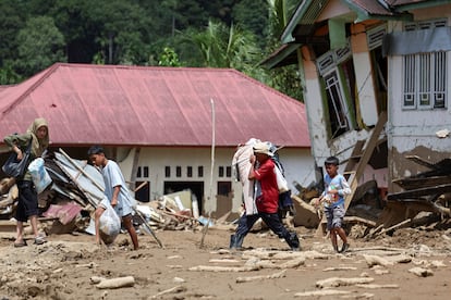 Familia recoge objetos de valor de su casa, gravemente dañada tras las inundaciones en Sumatra Occidental (Indonesia)