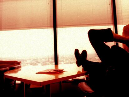 Un hombre se relaja en su despacho disfrutando de las vistas.