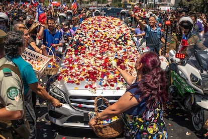 La carroza fúnebre que transporta los restos de Sebastián Piñera cubierta por pétalos.