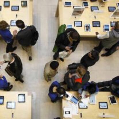 Clientes buscan en las mesas en las que se muestran el Apple IPAD 4G listo para Tablet PC en una de sus tiendas en París, 16 de marzo 2012.