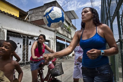 En las favelas de Rio de Janeiro, muchos jóvenes sueñan con ser algún día una gran estrella del fútbol. También chicas como Aline, de 32 años, que en la imagen juega con una pelota de fútbol, junto al campo de la favela no pacificada Vigario Geral. Ella es jugadora profesional y profesora de educación física, tras haber estudiado la carrera universitaria de deporte y educación física, aunque tiene que ganarse la vida preparando comida para vender.