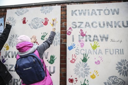 Una mujer deja la huella de la palma de su mano en el "muro de la furia" ante la sede del Partido de Ley y Justicia en Varsovia (Polonia).