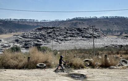 Un niño camina en el barrio de Escalerillas con el basurero municipal al fondo en Chimalhuacan, Estado de México.