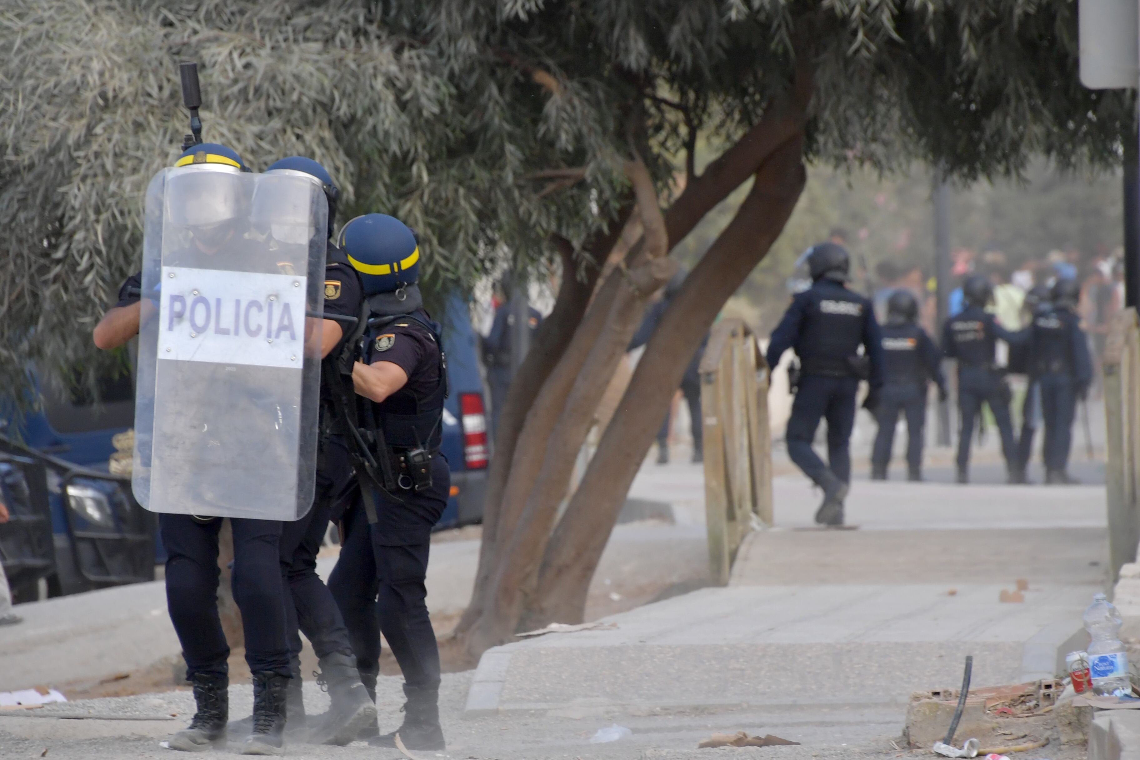 Agentes policiales tratan de frenar los enfrentamientos entre ceutíes y migrantes en la playa de El Trampolín, el miércoles.