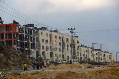 Palestinos caminan cerca de edificos que fueron destruidos durante la guerra de 50 días entre Israel y militanes de Hamas en el verano de 2014 en Beit Hanun (Franja de Gaza).