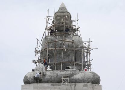 Trabajadores en andamios alrededor de una estatua gigante de Buda en el templo Tapong Nok, en la provincia de Rayong, al este de Tailandia.