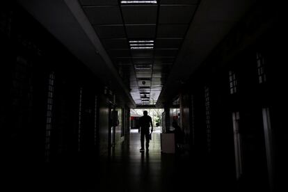 Un hombre camina por un pasillo a oscuras de un edificio en Caracas (Venezuela), este martes. El líder chavista Maduro ordenó desde el lunes el cese de las actividades laborales y educativas que se mantendrá este miércoles sin que hasta ahora haya certezas sobre el retorno pleno de la electricidad.
