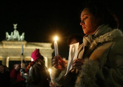 12 de marzo de 2004. Berlín. Las muestras de apoyo a las víctimas y de condena a los ataques se dieron por todo el mundo. En la fotografía, la española Carmen Martín, sostiene una vela y un lazo negro frente a la Puerta de Brandenburgo.