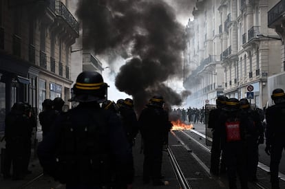 Varios manifestantes queman contenedores en Burdeos durante las protestas contra la reforma de las pensiones del presidente Macron, este jueves.